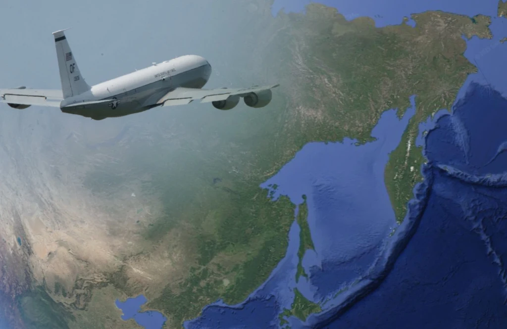 Amerykański samolot, który bada atmosferę na obecność śladów nuklearny, zauważony w pobliżu rosyjskiego wybrzeża Wojskowy samolot odrzutowy leci nad dużym obszarem Ziemi widocznym z perspektywy satelitarnej, obejmującym wybrzeża, morza i lądy Azji północno-wschodniej.