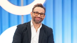 Stylista fryzur Maciej Maniewski w białej koszuli i czarnej marynarce, uśmiechnięty