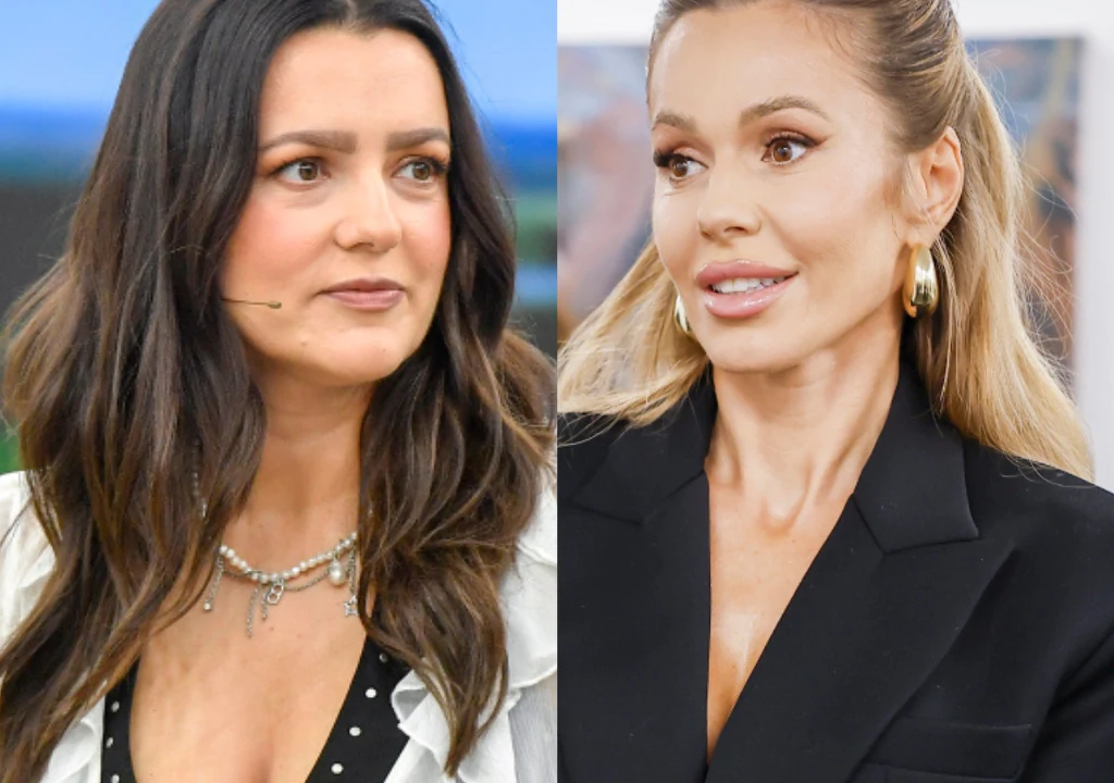 Doda, Lanberry Dwie kobiety ubrane elegancko, jedna o ciemnych włosach w białej bluzce z naszyjnikiem, druga o jasnych włosach upiętych w kucyk, w czarnym żakiecie i złotych kolczykach, obie zwrócone twarzami lekko do siebie.