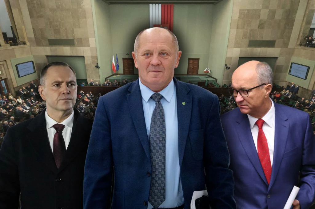 Trzech elegancko ubranych mężczyzn w garniturach stoi na tle sali sejmowej, z widocznymi polskimi flagami i liczną publicznością na widowni.