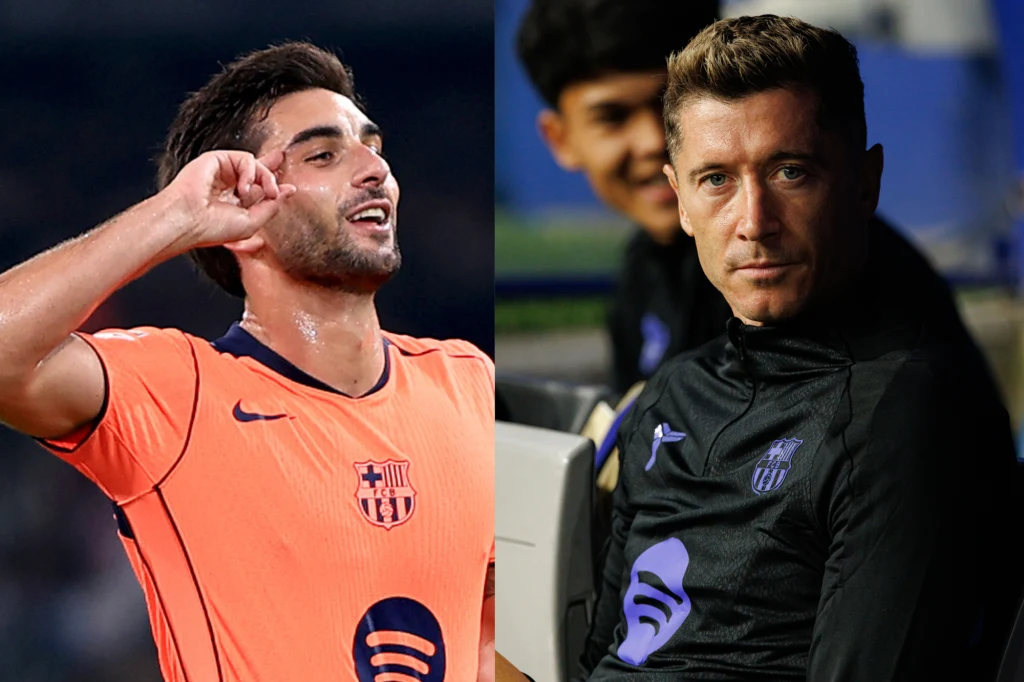 Ferran Torres i Robert Lewandowski Po lewej stronie sportowiec w pomarańczowej koszulce FC Barcelony wykonuje gest dłonią przy uchu, po prawej zawodnik tej samej drużyny w dresie sportowym siedzi na ławce rezerwowych.