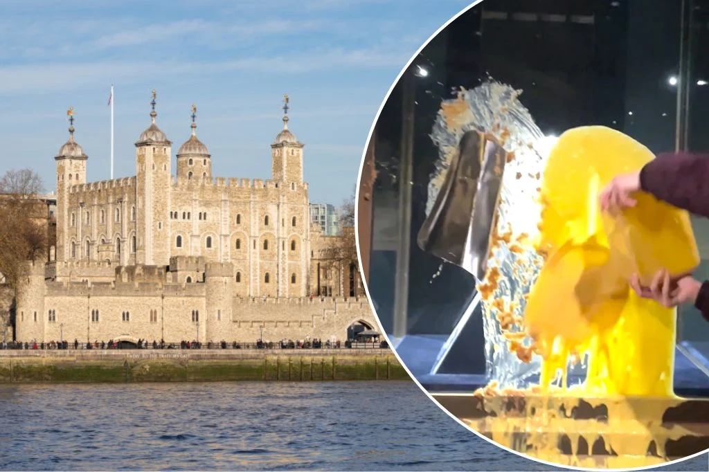 Widok na słynną londyńską Tower of London nad brzegiem Tamizy, a w okrągłym kadrze zbliżenie na dynamiczny moment rozbicia dużego żółtego przedmiotu, przypominającego wosk lub plastik, za pomocą metalowej płyty, z której rozbryzguje się materiał na wsz...