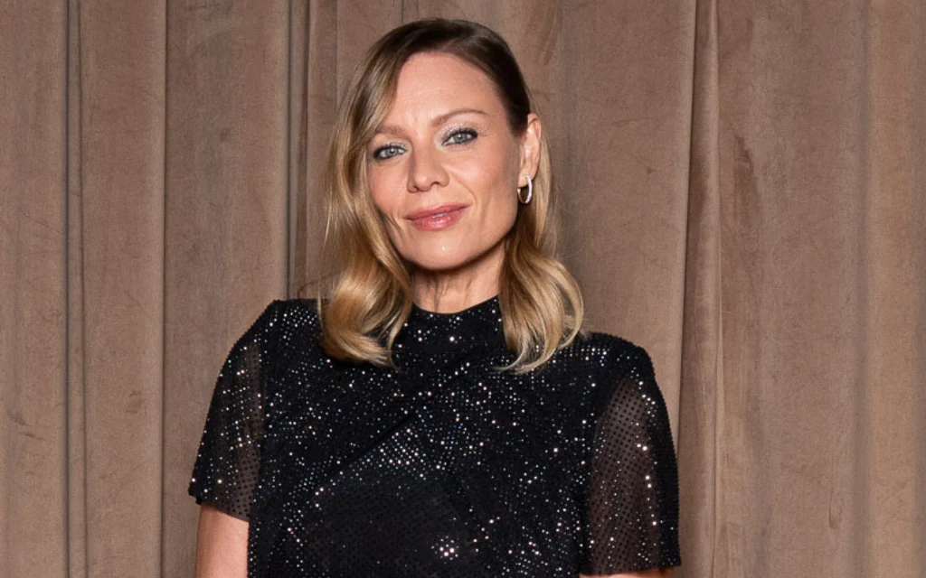 Elegancka kobieta w czarnej błyszczącej sukience.