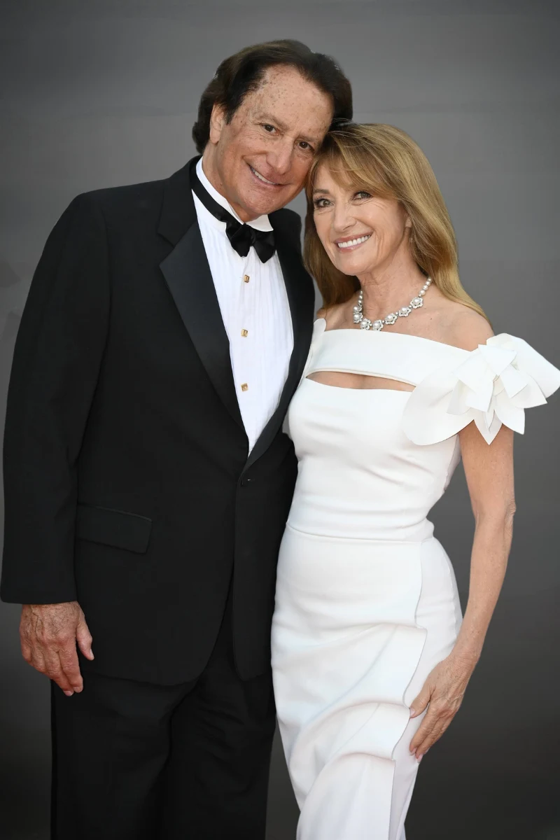 Jane Seymour i John Zambetti w eleganckich kreacjach, przytulają się i uśmiechają