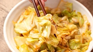 kapusta pekińska w kawałkach, w misce, duszona z sezamem i czosnkiem, pałeczki do jedzenia