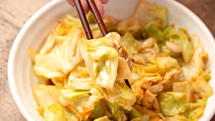 kapusta pekińska w kawałkach, w misce, duszona z sezamem i czosnkiem, pałeczki do jedzenia