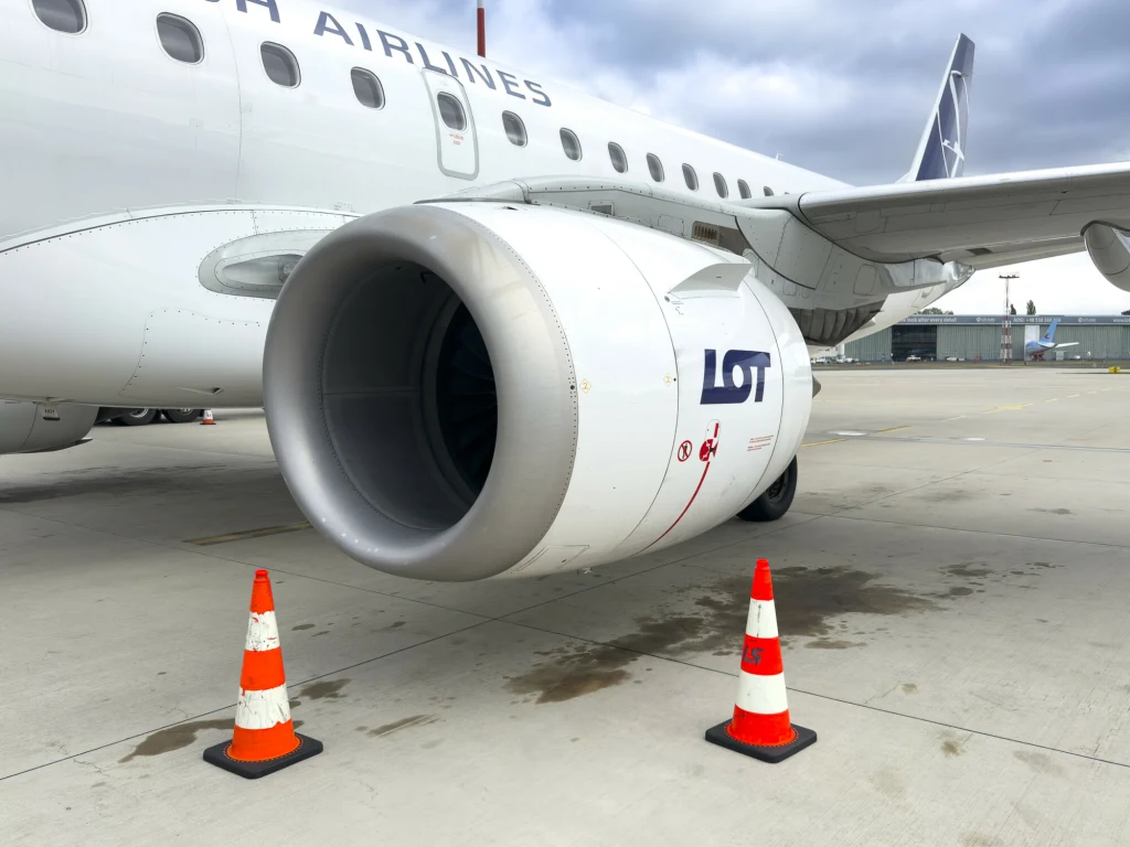 Czeskie linie lotnicze nie dla LOT-u Silnik odrzutowy samolotu pasażerskiego ustawionego na płycie lotniska, otoczony dwiema pomarańczowo-białymi pachołkami bezpieczeństwa. Na silniku widoczne logo LOT.