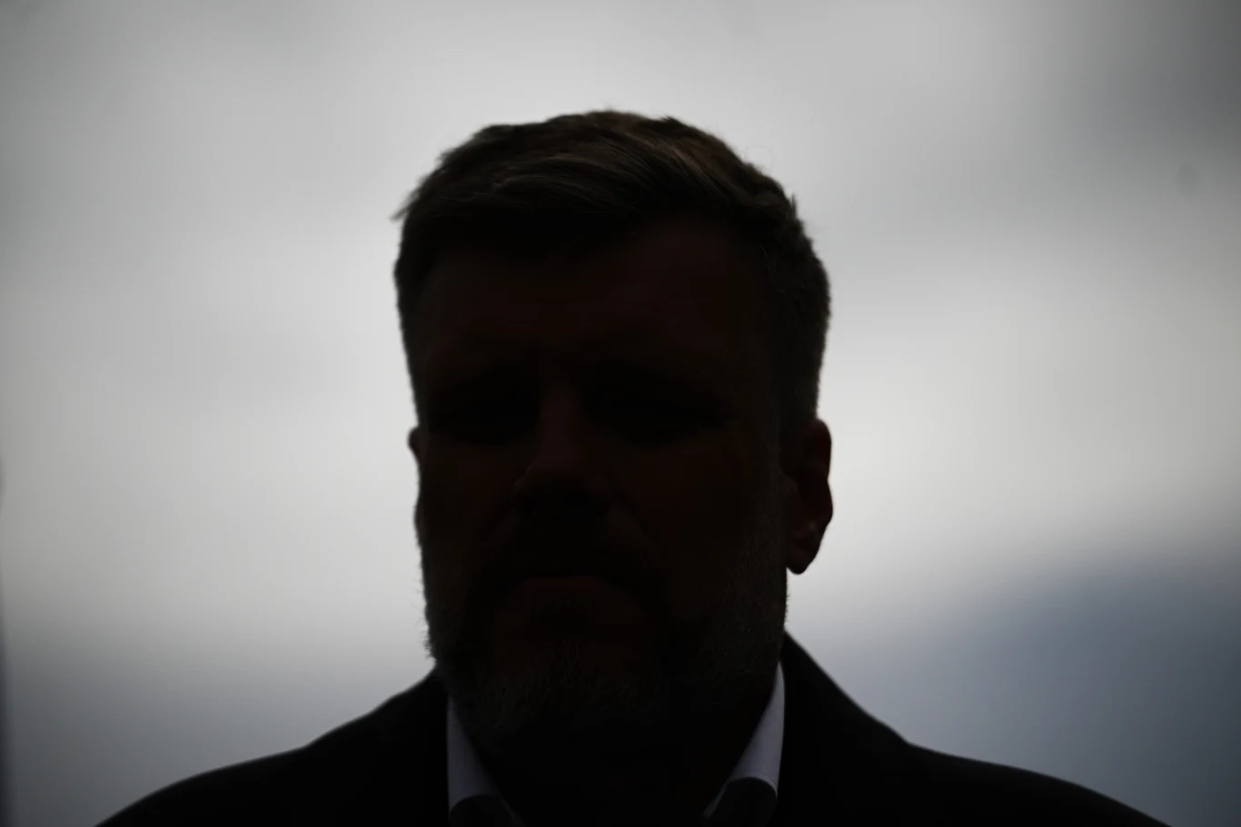 Adrian Zandberg wyjdzie z cienia dawnej SLD-owskiej lewicy? Sylwetka mężczyzny w ciemnym ubraniu na tle jasnego, rozmytego nieba, twarz niewidoczna z powodu silnego cienia.