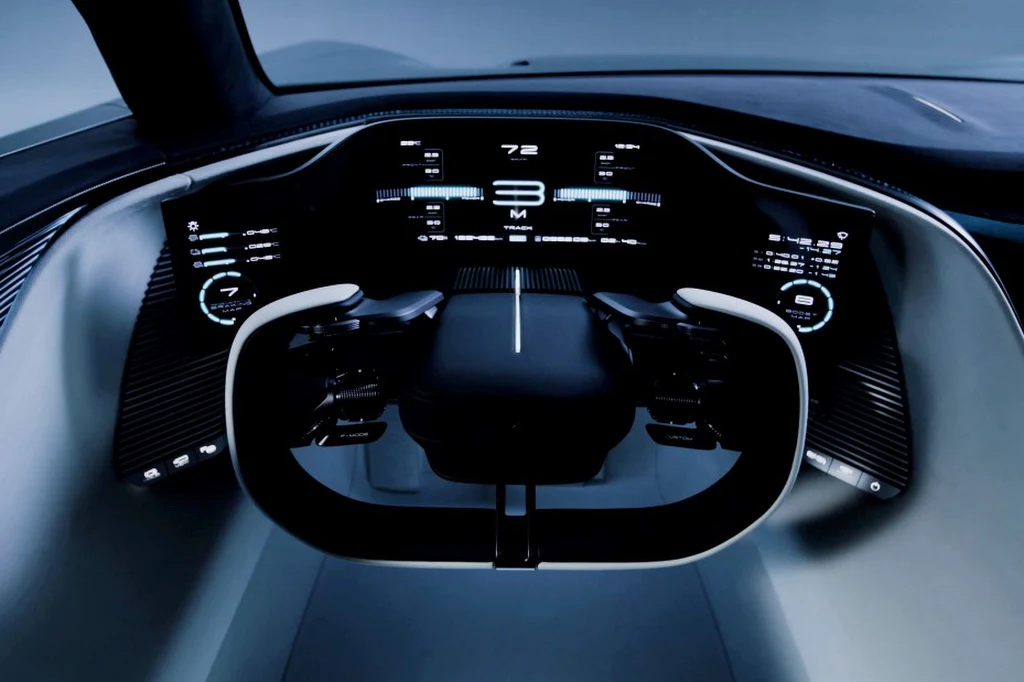 Nowoczesny, futurystyczny kokpit samochodu z cyfrowymi wyświetlaczami, dotykowymi panelami sterowania oraz innowacyjną kierownicą o nietypowym kształcie.