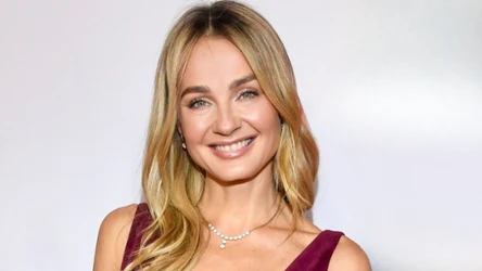 Małgorzata Socha w rozpuszczonych włosach, bordowej sukience z weluru, zdjęcie do dekoltu