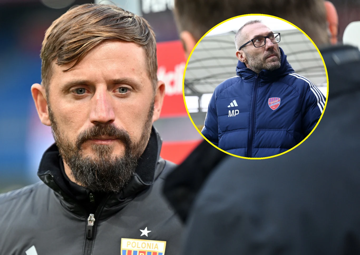 Łukasz Tomczyk zastąpi w Rakowie Marka Papszuna Mężczyzna z krótkimi brązowymi włosami i brodą w kurtce sportowej z godłem Polonia oraz drugi mężczyzna w okrągłej ramce noszący okulary i niebieską kurtkę z logo klubu piłkarskiego, rozmawiający lub obserwujący coś poza kadrem.