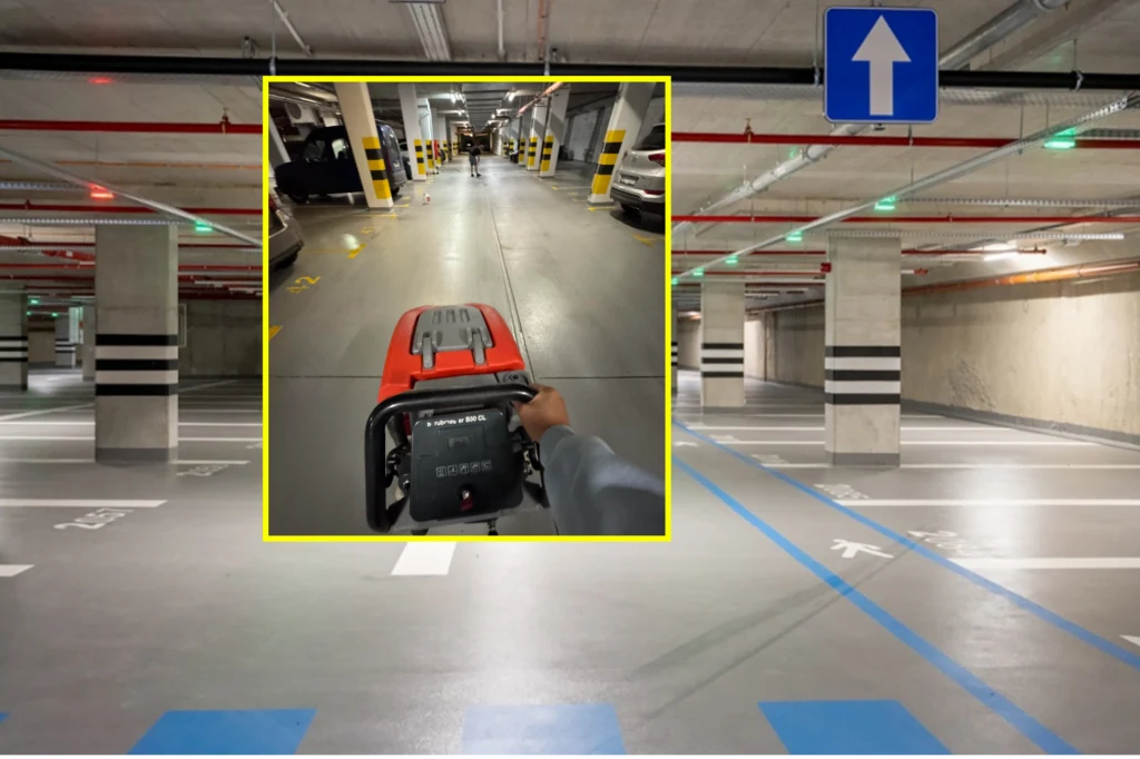 Ubrudził posadzkę w garażu podziemny. Administracja żąda zapłaty 169 tys. zł. / Fot. Rafał Motyl UM Warszawa i Hi_5 Pozornie zwyczajny podziemny parking samochodowy z pustymi miejscami, żółto-czarnymi słupami ochronnymi i niebieskimi liniami wyznaczającymi miejsca dla osób niepełnosprawnych; w centralnej części obrazu wyodrębniono mniejsze zdjęcie pokazujące osobę t...