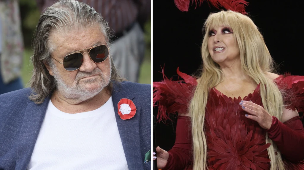 Andrzej Jaroszewicz, Maryla Rodowicz Mężczyzna w ciemnych okularach i granatowej marynarce z przypiętym biało-czerwonym kotylionem po lewej stronie oraz kobieta w efektownej czerwonej kreacji z długimi blond włosami po prawej stronie, uśmiechnięta, wykonująca gest ręką.