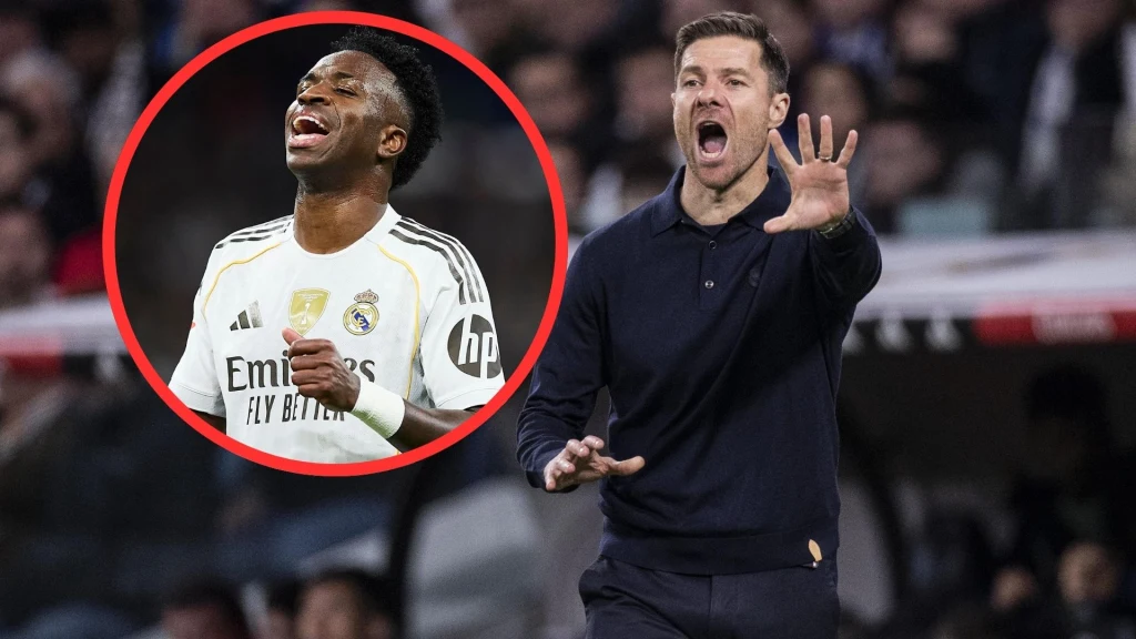 Xabi Alonso i Vinicius Jr. Piłkarz w białym stroju Realu Madryt w geście radości, w tle trener w granatowym swetrze wydający polecenia podczas meczu.