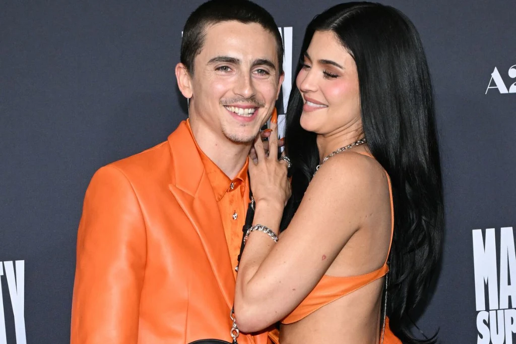 Para ucięła plotki na temat ich rozstania Para ubrana w odcienie pomarańczu pozuje razem na tle ścianki promocyjnej podczas wydarzenia, oboje wyglądają na szczęśliwych, kobieta delikatnie dotyka twarzy mężczyzny.