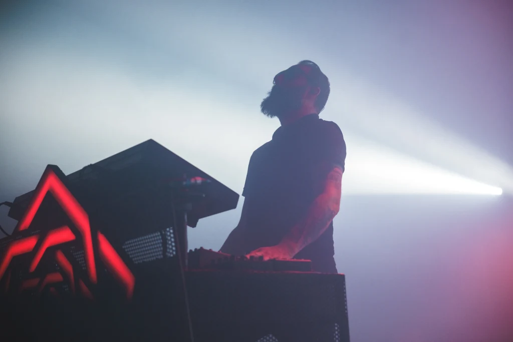 Carpenter Brut wystąpi podczas Mystic Festival 2026 w Gdańsku Mężczyzna z brodą obsługujący konsolę muzyczną podczas występu na scenie, oświetlenie w tle tworzy dynamiczną atmosferę koncertu.