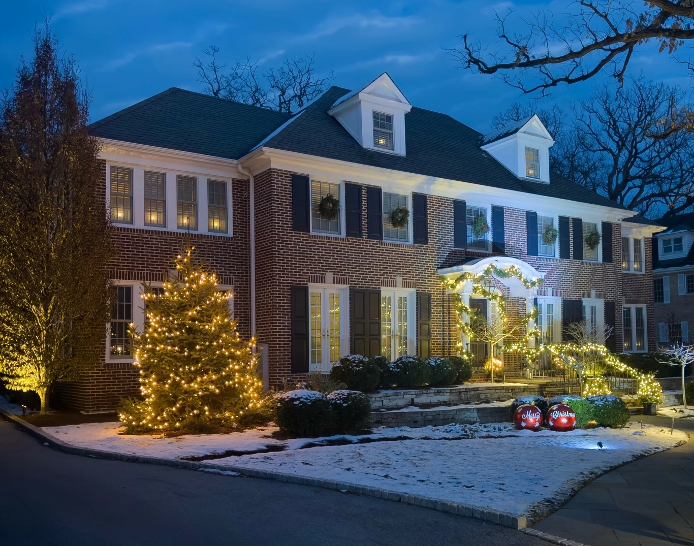 Dziś wnętrza słynnego domu pozbawione są kiczu i przepychu, za którymi wiele osób tęskni Dwupiętrowy dom z czerwonej cegły ozdobiony świątecznymi lampkami i girlandami, przed wejściem świecące dekoracje i ozdobione drzewko bożonarodzeniowe, wokół lekko przysypany śniegiem trawnik, atmosfera zimowego wieczoru.