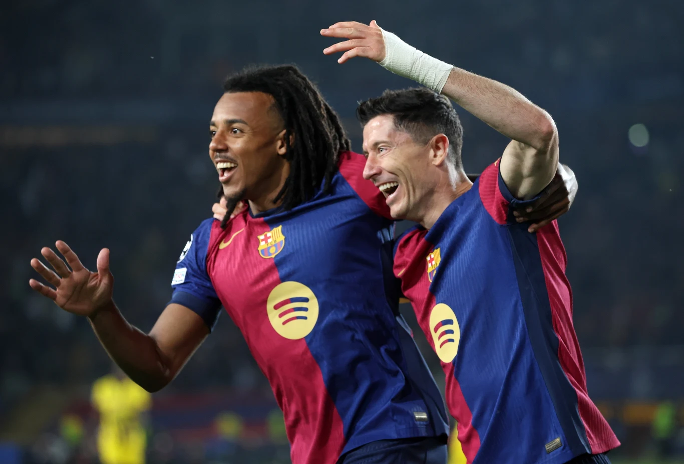 Jules Kounde i Robert Lewandowski Dwóch piłkarzy w strojach FC Barcelony cieszy się po zdobyciu gola, obejmując się i uśmiechając na stadionie podczas meczu piłkarskiego.