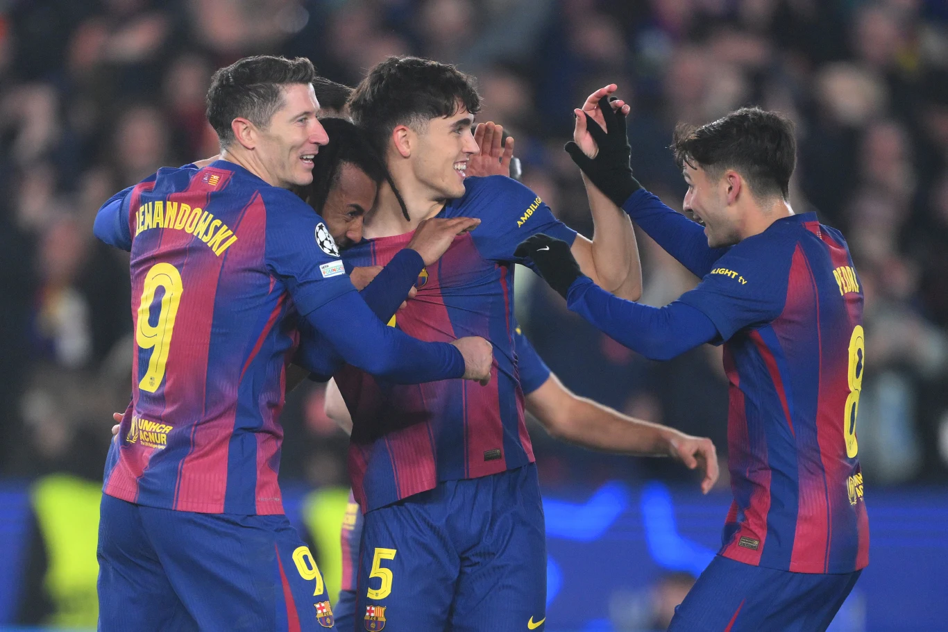 Piłkarze Barcelony Piłkarze w niebiesko-czerwonych strojach FC Barcelony świętują zdobycie gola, stojąc blisko siebie, uśmiechając się i okazując radość w grupie podczas meczu na stadionie.