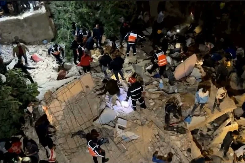 Dwa budynki zawaliły się w marokańskim mieście Fez Grupa ratowników i ludzi w odblaskowych kamizelkach przeszukuje gruzowisko zawalonego budynku nocą, używając latarek i sprzętu ratowniczego. Między gruzami widoczne są fragmenty ścian i rozbitych elementów konstrukcyjnych.