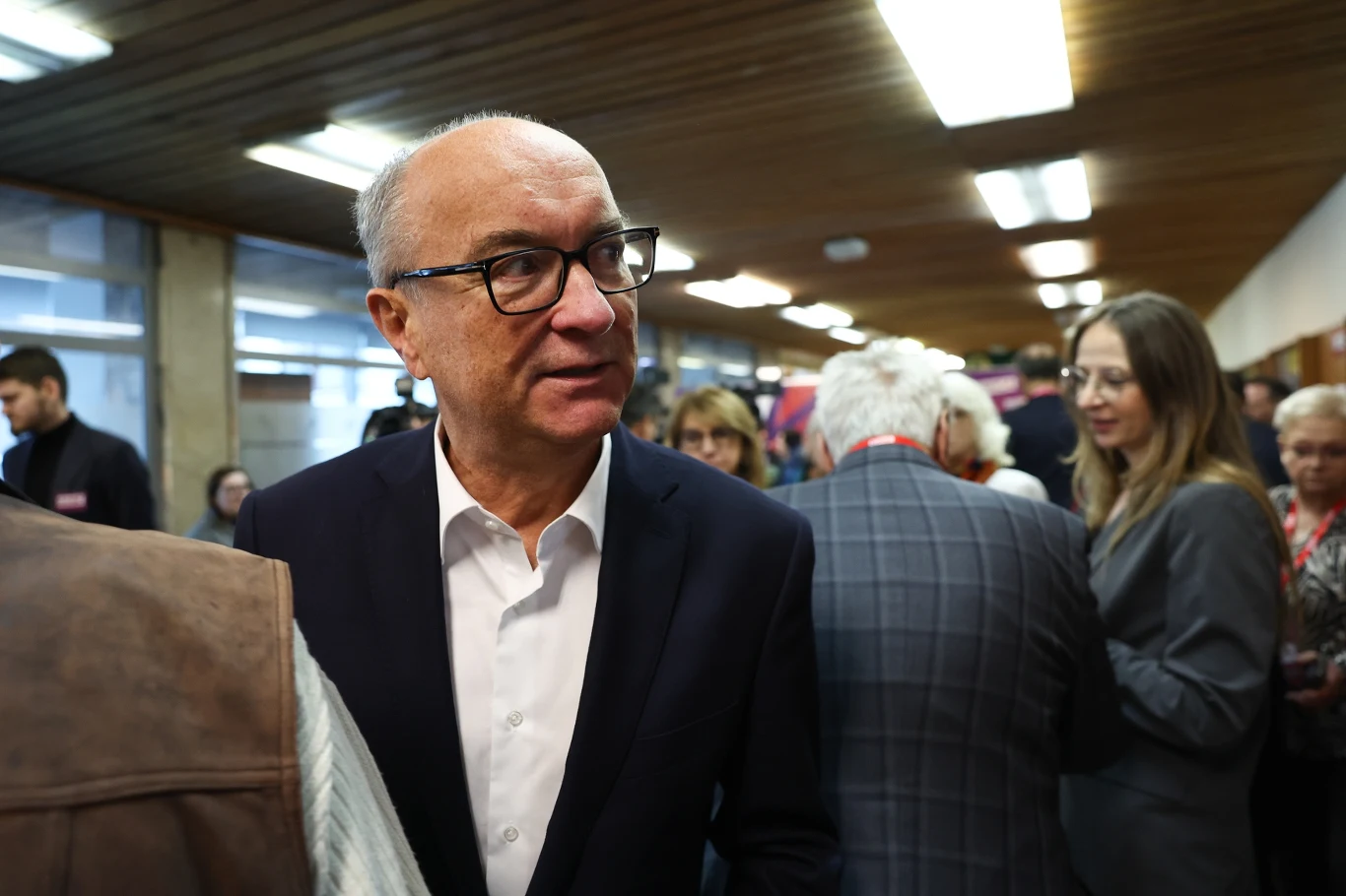 Włodzimierz Czarzasty jest faworytem, ale Agnieszka Dziemianowicz-Bąk (na drugim planie) będzie chciała pokazać siłę kobiet lewicy Mężczyzna w okularach i garniturze na tle grupy ludzi w budynku ze świetlówkowym oświetleniem, wśród uczestników panuje atmosfera spotkania lub wydarzenia formalnego.