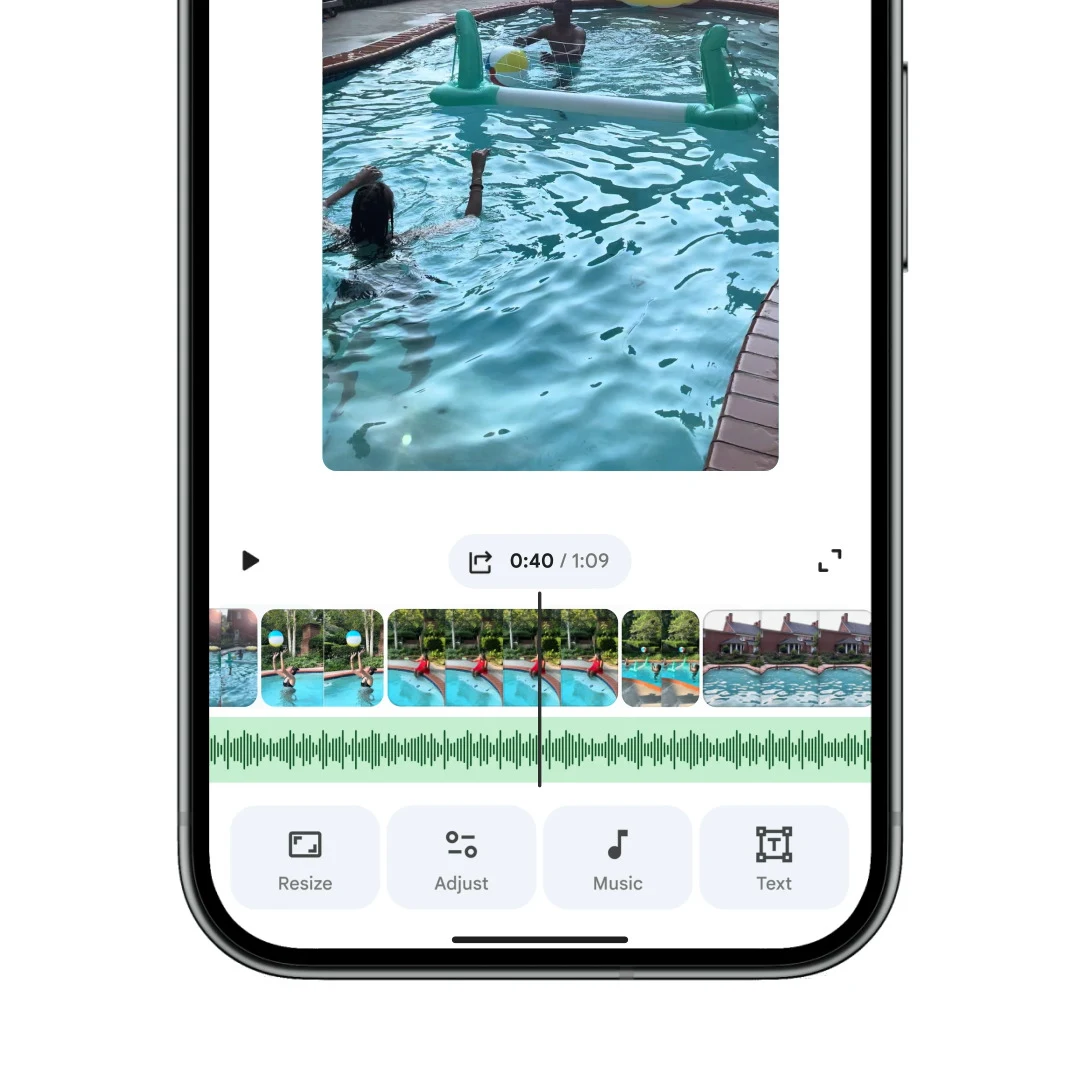 Ekran smartfona prezentuje aplikację do edycji wideo, na której widoczny jest kadr z basenu z osobą pływającą oraz dmuchanym rekinem. Na dole ekranu znajdują się narzędzia edycji i linia czasu filmu.