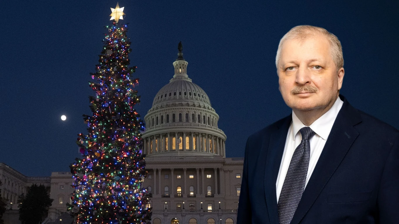 Rosyjski ambasador świętował w Kapitolu. "Wspaniałe wydarzenie" (zdj. ilustracyjne) Mężczyzna w garniturze pozuje na tle oświetlonej choinki oraz gmachu Kapitolu w Waszyngtonie, rozświetlonego w nocy.