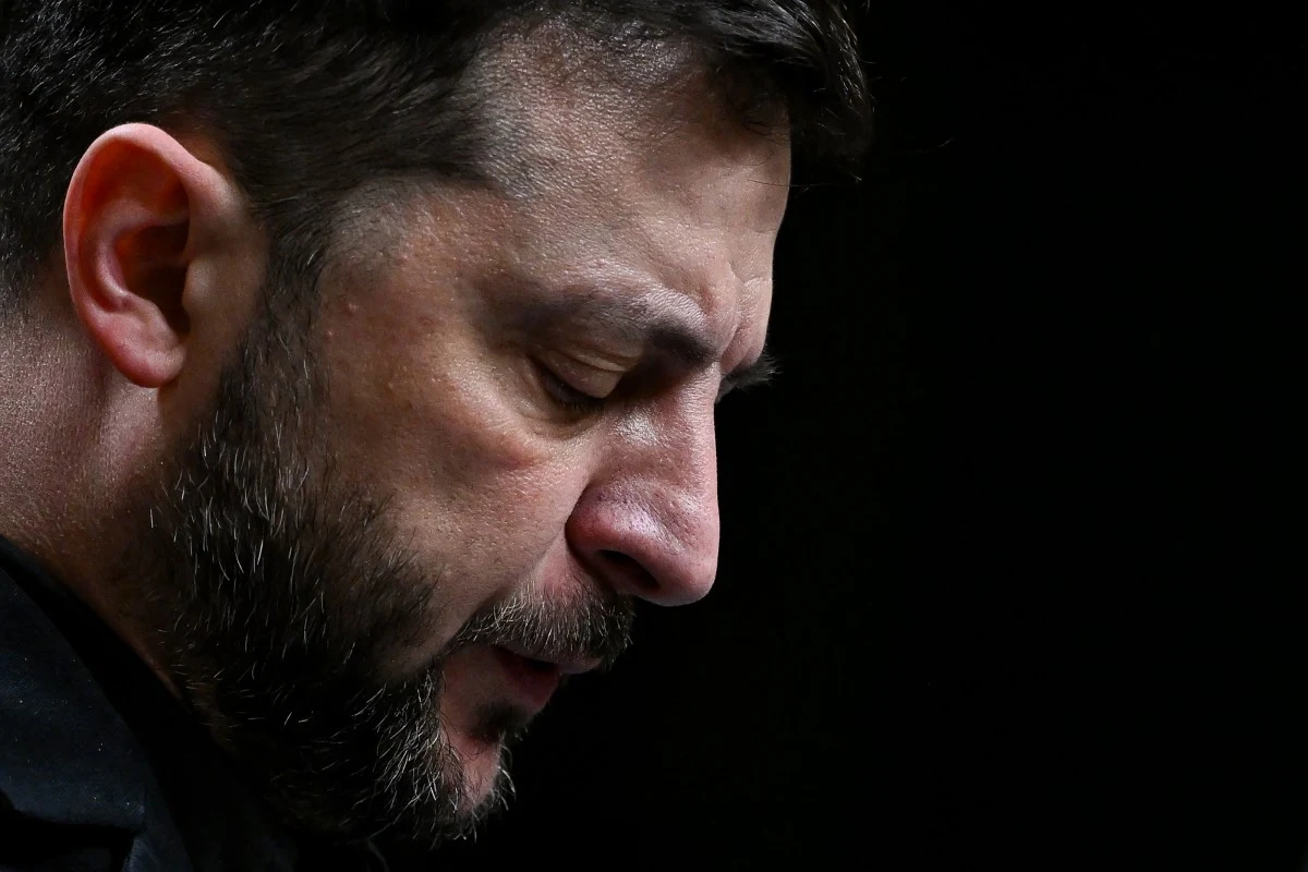 Wołodymyr Zełenski musi zmierzyć się z wyjątkowo trudnym dylematem Zbliżenie twarzy mężczyzny z brodą i krótkimi włosami, patrzącego w dół, na tle ciemnym. Wyraz twarzy skupiony i zamyślony.