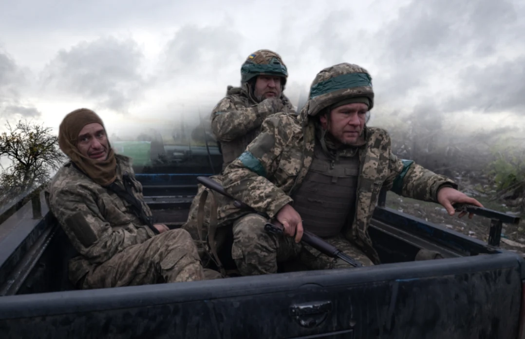 Ukraińska prokuratura utajniła dane dotyczące liczby dezercji Trzech żołnierzy w mundurach wojskowych siedzi w tylnej części pojazdu terenowego. Ich twarze wyrażają skupienie i zmęczenie, otacza ich zamglony, nieprzyjazny krajobraz, co podkreśla atmosferę napięcia i trudnych warunków.