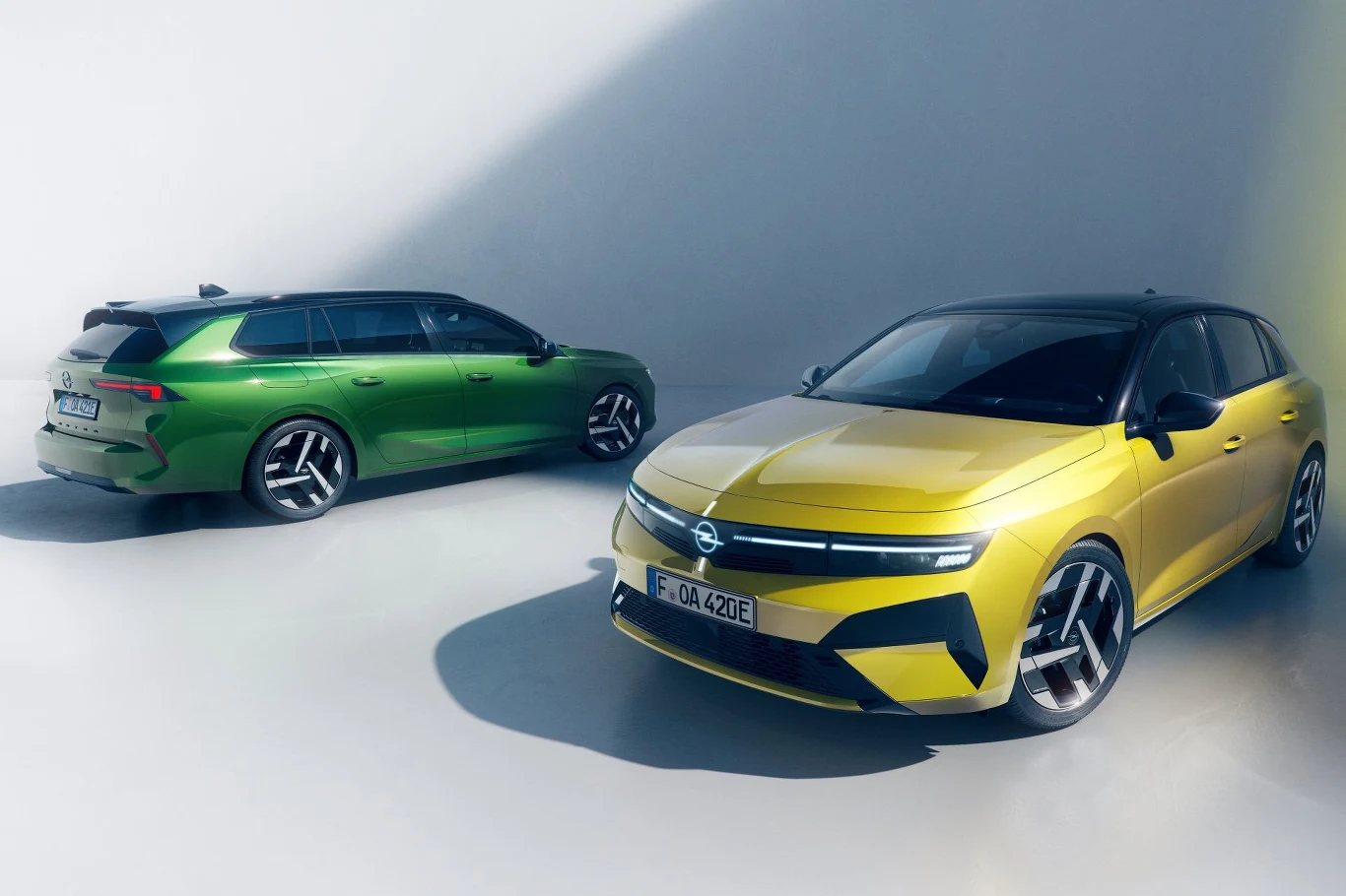 Opel Astra po modernizacji zostanie zaprezentowany w styczniu 2026 roku. Dwa nowoczesne samochody osobowe w jaskrawych kolorach, jeden w metaliczno-zielonym, drugi w intensywnie żółtym, ustawione na jasnym tle, podkreślającym ich sportowy charakter i nowoczesny design.