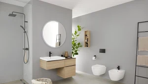 Szara łazienka z jasną szafką podumywalkową, prysznicem walk-in, miską WC i bidetem