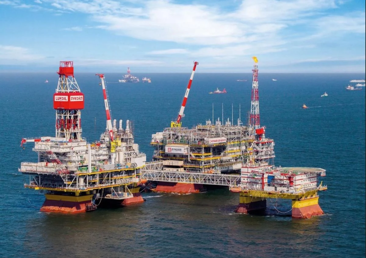 Platforma im. Władimira Filanowskiego na Morzu Kaspijskim Platformy wiertnicze na morzu z widocznymi zabudowaniami technicznymi, otoczone wodą i z kilkoma mniejszymi jednostkami pływającymi na horyzoncie. Klarowna pogoda, niebo częściowo zachmurzone.