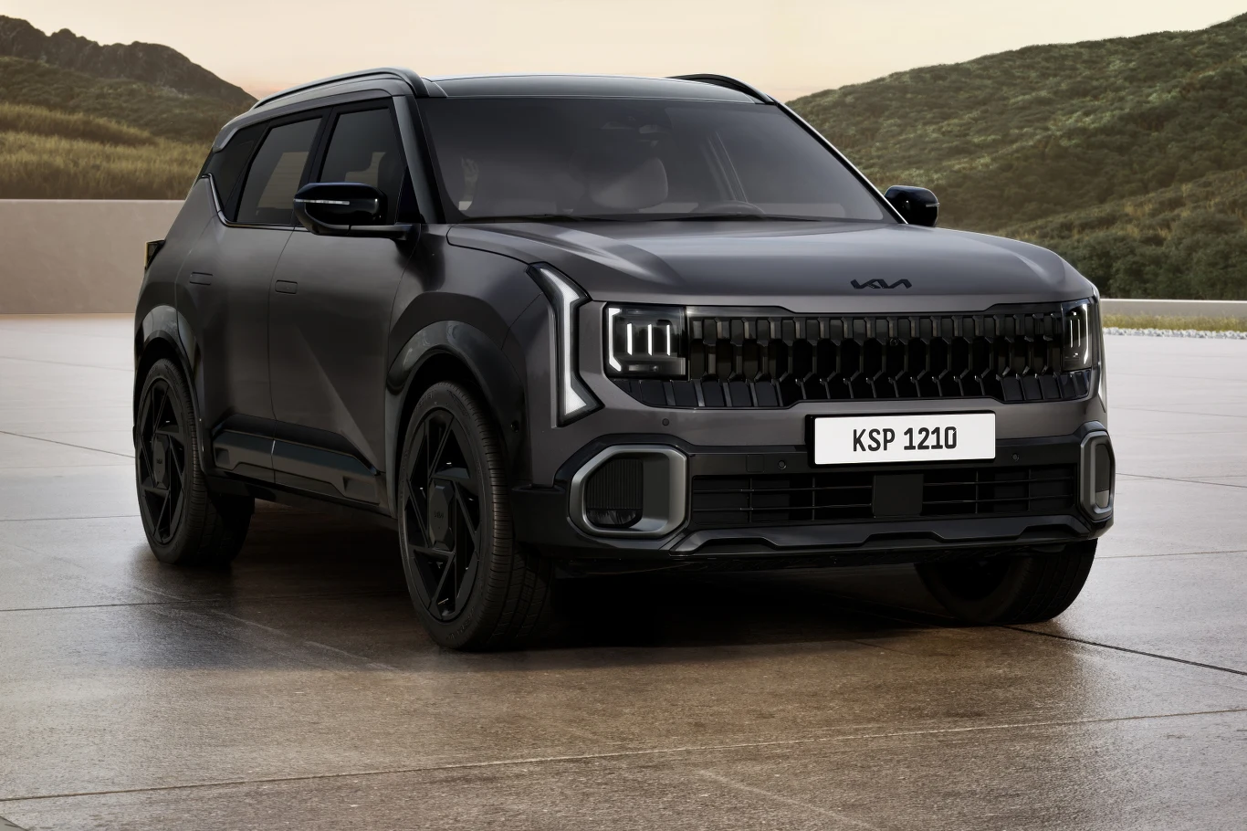 Z czasem w ofercie pojawi się również wersja hybrydowa Nowoczesny, czarny SUV marki Kia z charakterystycznym przodem, dynamicznymi liniami nadwozia i czarnymi felgami, stojący na utwardzonej powierzchni na tle zielonych wzgórz.