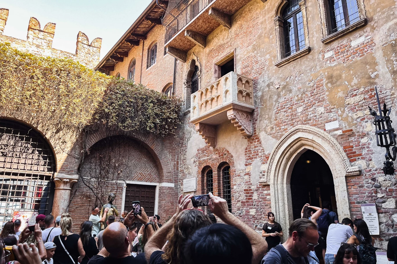 Turyści, którzy chcą zobaczyć słynny balkon Julii, muszą zapłacić za wstęp Dziedziniec słynnego domu Julii w Weronie z widocznym balkonem, na którym według legendy rozgrywała się scena z dramatu Szekspira. Liczna grupa turystów fotografuje i obserwuje zabytkowe mury oraz charakterystyczny balkon.