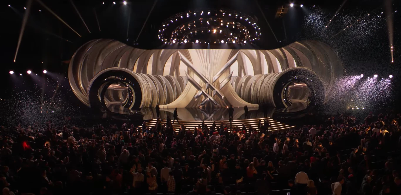 The Game Awards 2025 Tłum ludzi zgromadzony przed widowiskową sceną z efektowną oprawą świetlną, dekoracjami i opadającym konfetti, całość utrzymana w atmosferze wielkiego wydarzenia artystycznego lub gali.
