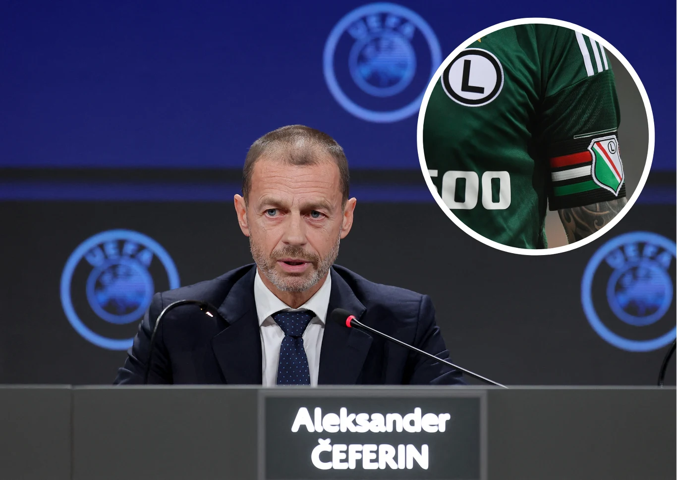 Aleksander Ceferin Mężczyzna w garniturze siedzący za stołem konferencyjnym z tabliczką z imieniem i nazwiskiem Aleksander Čeferin, w tle niebieskie logo UEFA, w prawym górnym rogu wstawka z fragmentem ramienia piłkarza w zielonej koszulce z herbem klubu Legia Warszawa.