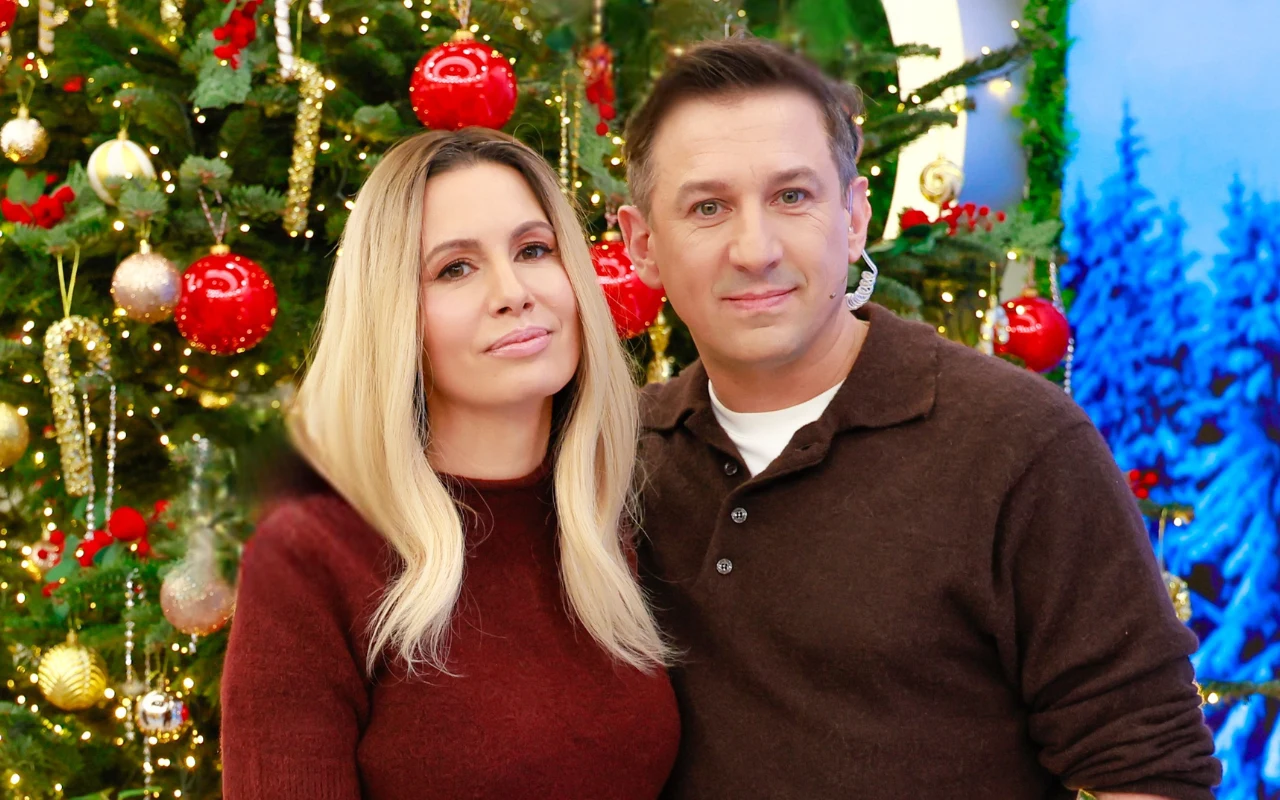 Agnieszka Hyży i Maciej Rock w brązowych swetrach na tle choinki
