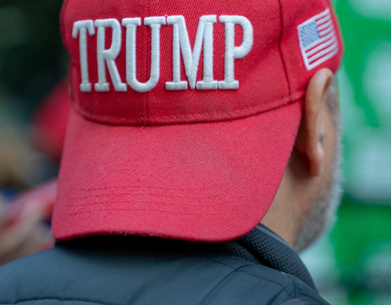 Wyborcy Donalda Trumpa, z którymi rozmawiał Reuters, nie obwiniają prezydenta USA za obecną wysoką inflację Czerwona czapka z daszkiem z białym napisem Trump oraz naszywką flagi Stanów Zjednoczonych, założona na głowie mężczyzny widzianego od tyłu.