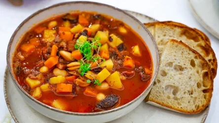 Zupa fasolowa z wędzoną śliwką, obok dwie kromki chleba