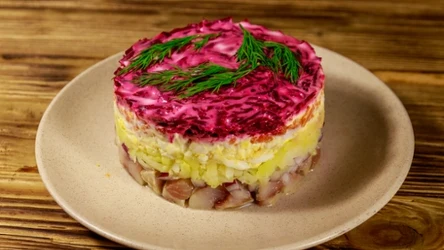 Śledzie pod pierzynką to świąteczna sałatka, w której w którym filety śledziowe układa się na dnie naczynia, a następnie przykrywa warstwami dodatków