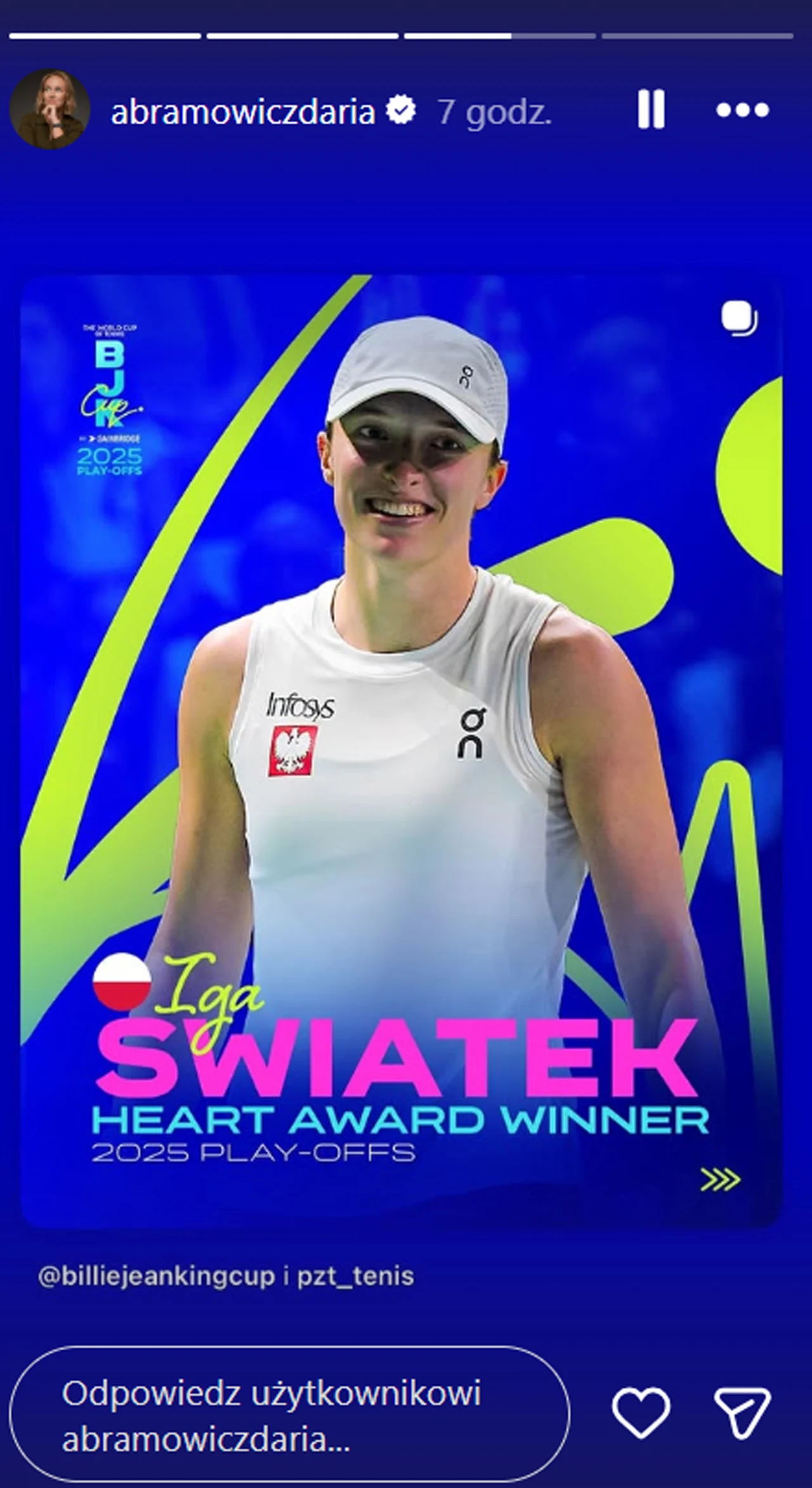 Uśmiechnięta tenisistka ubrana w biały strój sportowy i białą czapkę, na tle graficznym w niebieskich barwach z neonowymi akcentami, z napisem informującym o wygranej nagrodzie Heart Award Winner 2025 Play-Offs dla Igi Świątek.