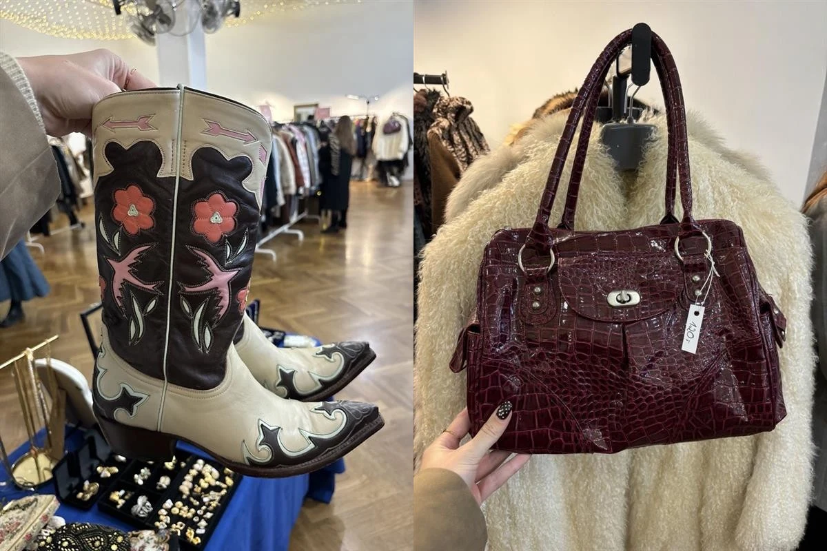 Kowbojskie buty z ozdobnymi motywami kwiatowymi oraz bordowa, lakierowana torebka z imitacji skóry krokodyla, trzymane na tle futrzanego płaszcza w sklepie z odzieżą vintage.