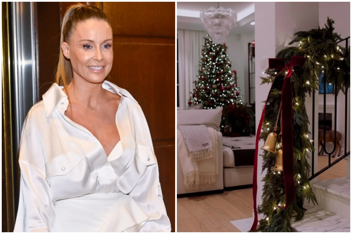 Uśmiechnięta kobieta w białej bluzce z włosami spiętymi w kucyk oraz świątecznie udekorowane wnętrze salonu z choinką, girlandą z gałązek i szarfą na poręczy schodów.