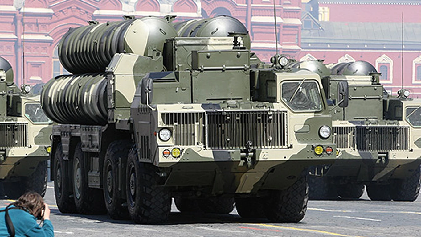 Norwegia ogłosiła zakup rosyjskich pocisków do systemów S-300 dla Ukrainy Ciężarówka wojskowa przewożąca duże cylindryczne pociski lub elementy systemu rakietowego, stojąca na ulicy w otoczeniu budynków o charakterze historycznym. Przed pojazdem kuca fotograf z aparatem.