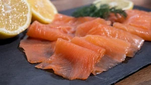 łosoś w plasterkach na czarnej płycie