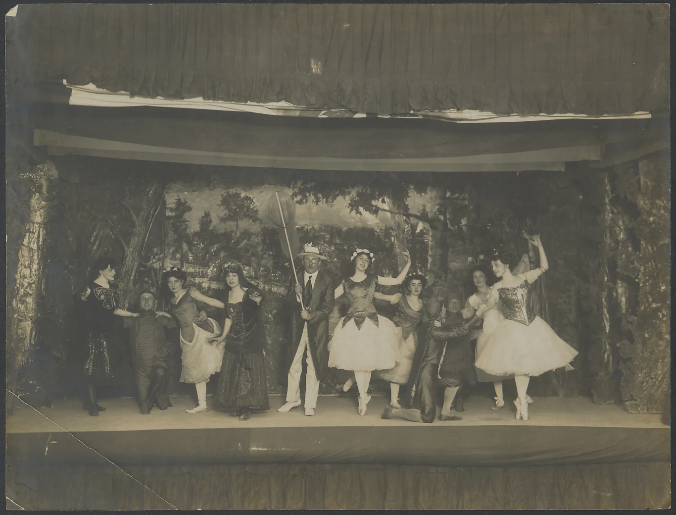 3 Program artystyczny wieczoru muzycznego zorganizowanego w Gospodzie Polskiej, 1916 rok Grupa aktorów w teatralnych kostiumach pozuje na scenie z malowaną, leśną scenografią w tle, część postaci nosi tiulowe spódnice, pozostałe są ubrane w historyczne stroje, panuje podniosła atmosfera występu.