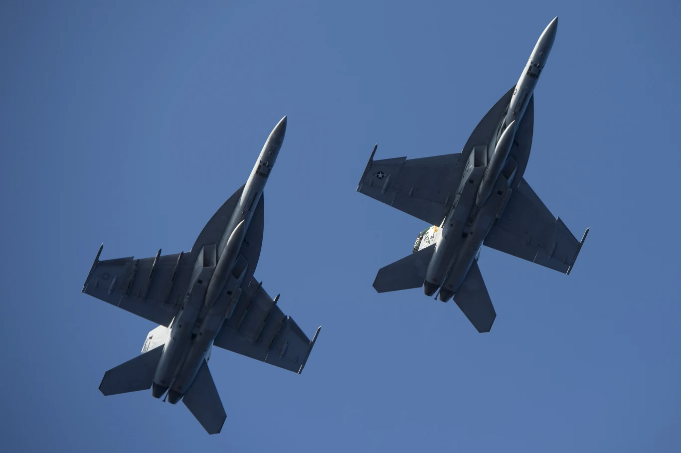 Ogromna flota amerykańskich samolotów pojawiła się nad Wenezuelą. Amerykanie naciskają Dwa myśliwce odrzutowe lecą równolegle na tle nieba, widoczne z dołu, oba w podobnym układzie skrzydeł, podkreślając nowoczesną technologię lotniczą.