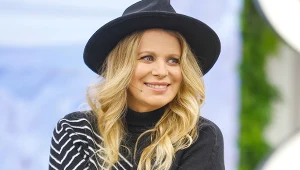 Uśmiechnięta Maria Sadowska w czarnym kapeluszu, rozpuszczonych włosach i czarnym swetrze