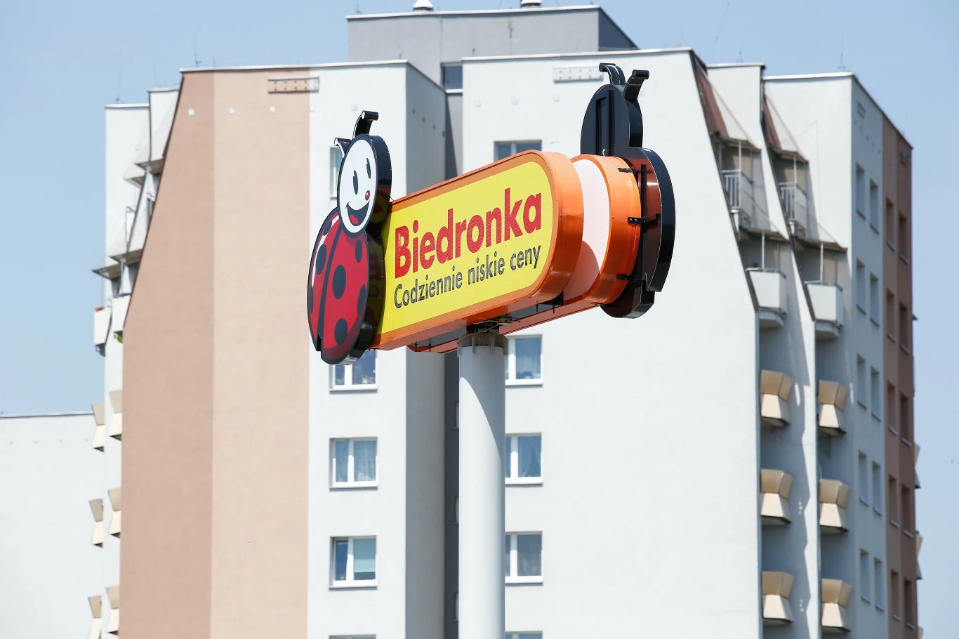 Projekt modernistycznej Biedronki w Katowicach wywołał wiele emocji Szyld sklepu Biedronka z logo w kształcie biedronki i hasłem Codziennie niskie ceny, umieszczony na tle bloku mieszkalnego.