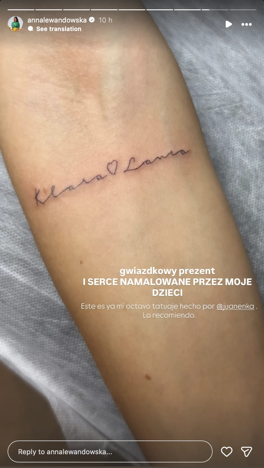 Fragment przedramienia z tatuażem przedstawiającym napis Klara Laura oraz niewielkie serce, wykonany delikatną linią w stylu odręcznego pisma.